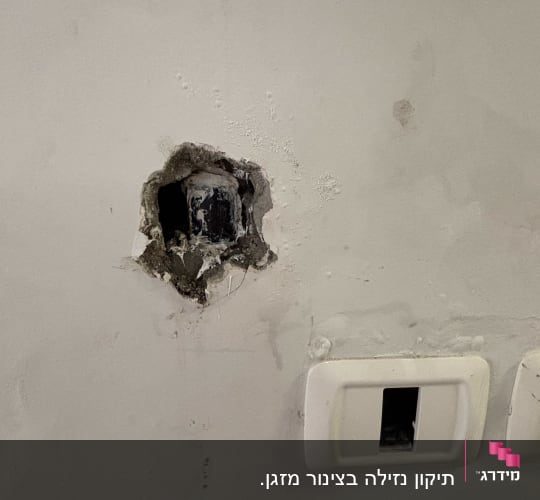 תמונה של קיר עם חור ותשתית חשמל